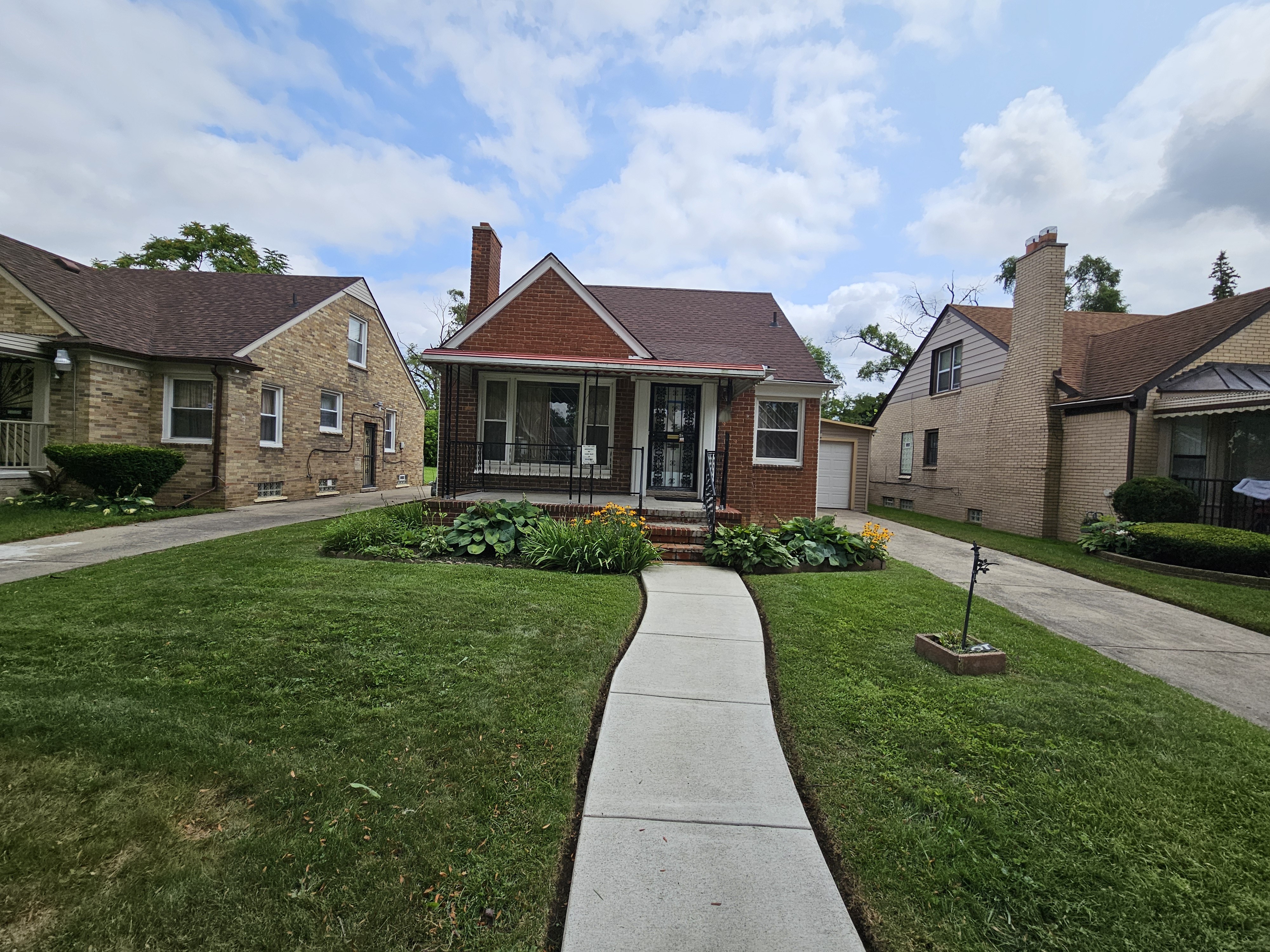 Landscaped front yard with clean edging by Malles Landscaping